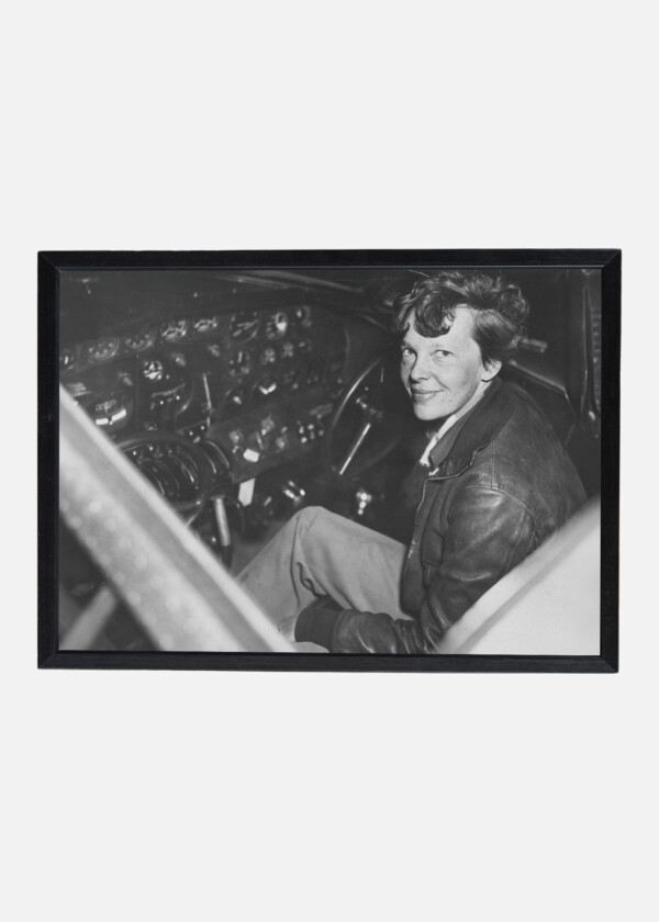 PHOTOGRAPH SHOWING AMELIA EARHART SITTING IN THE COCKPIT OF AN ELECTRA AIRPLANE.1937