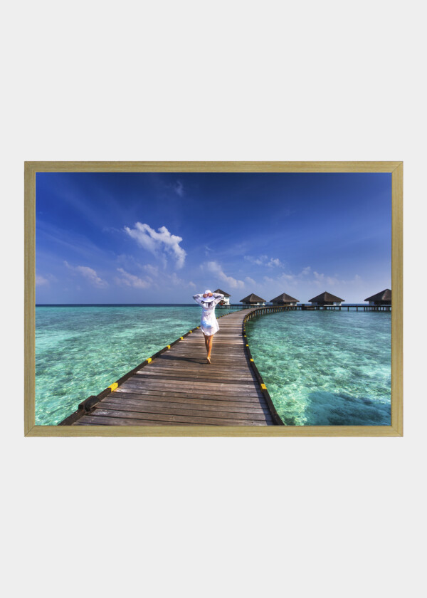 WOMAN WALKING ON WOODEN PIR IN EMERALD GREEN WATER