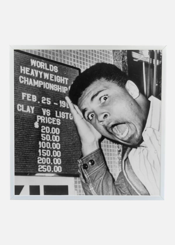 MUHAMMAD ALI, FORMERLY CASSIUS CLAY CLOWNS IN MOCK HORROR AT THE PRICES LISTED AT A BOX OFFICE WINDOW